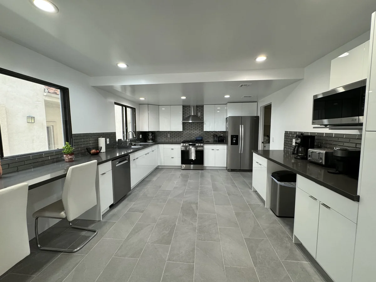 Wide view of the Burbank kitchen with a window-side breakfast counter and white cabinets
