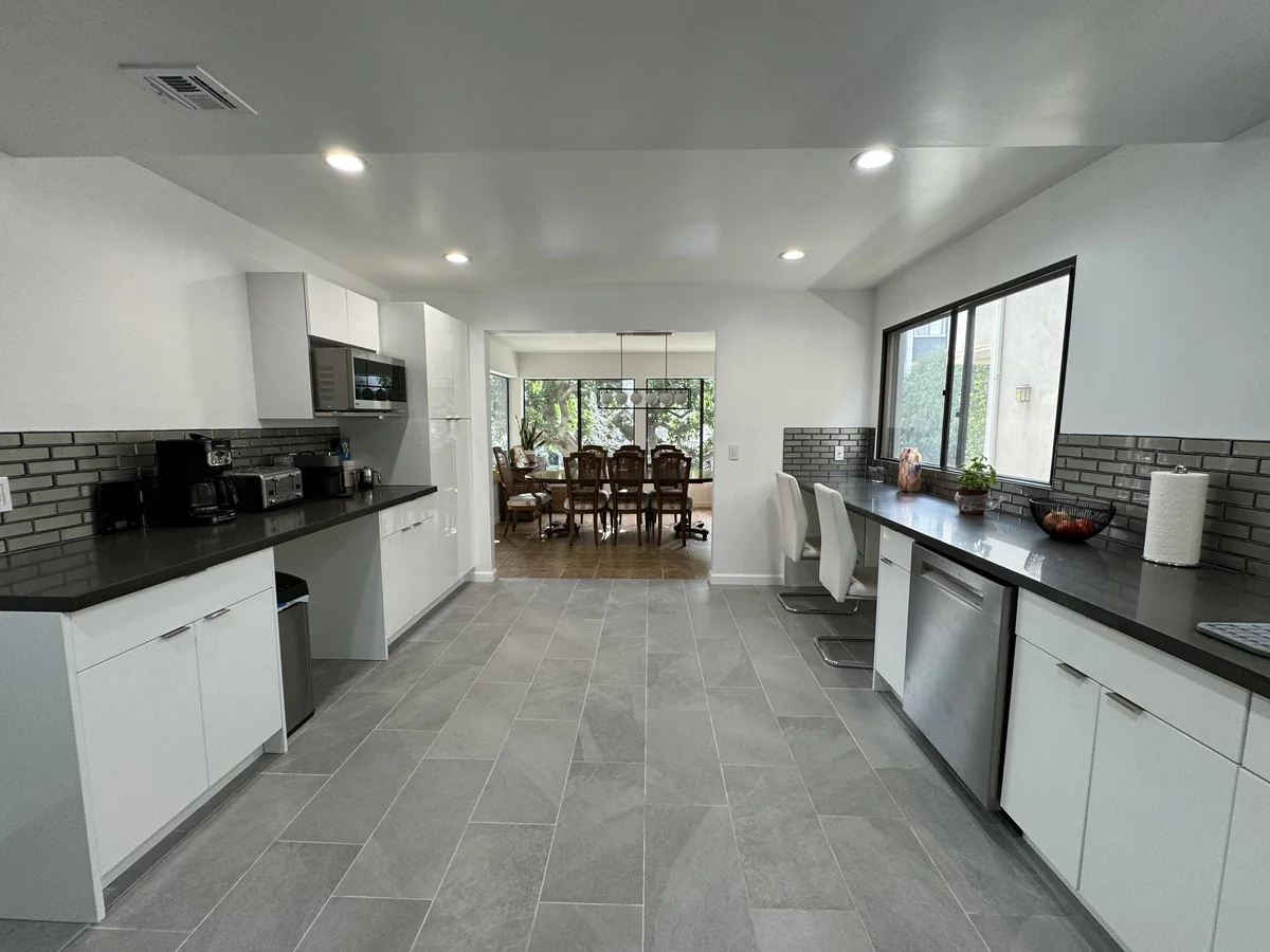 View through the kitchen toward the dining area with a breakfast counter along the window