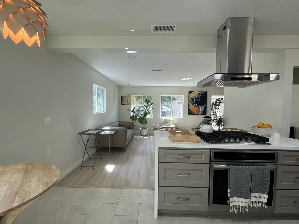 View from the dining area past the kitchen range and hood toward the adjoining living space