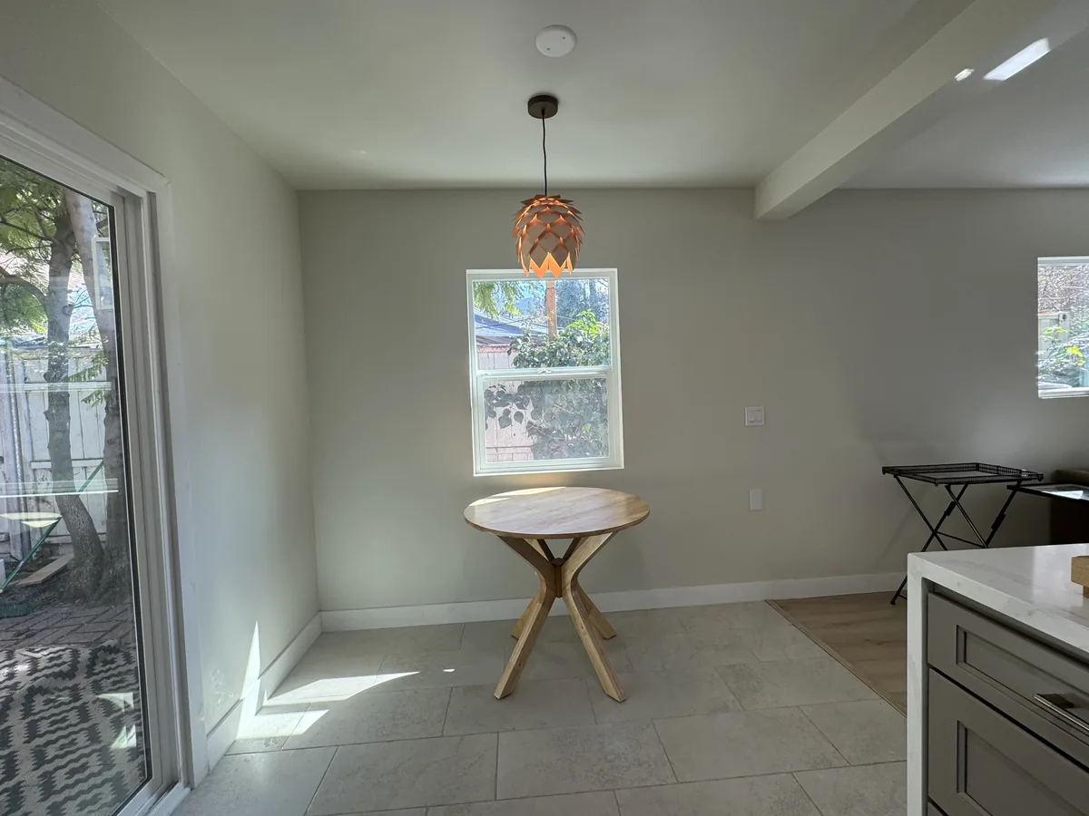 Dining nook beside sliding glass doors with a round table and gray kitchen cabinetry