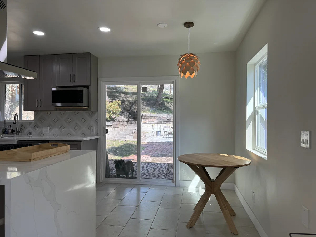 Gray cabinetry and built-in microwave beside the breakfast bar and sliding glass doors