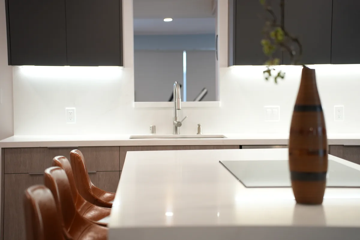 White island countertop and brown bar stools beside the kitchen sink