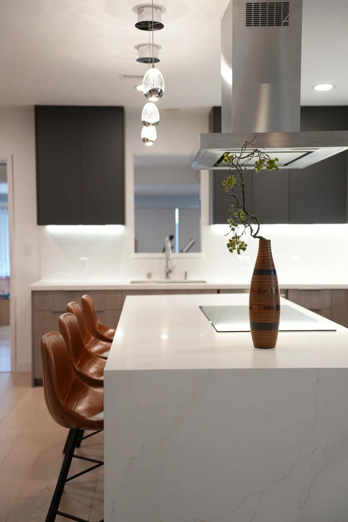 Waterfall edge of the white kitchen island with pendant lighting above