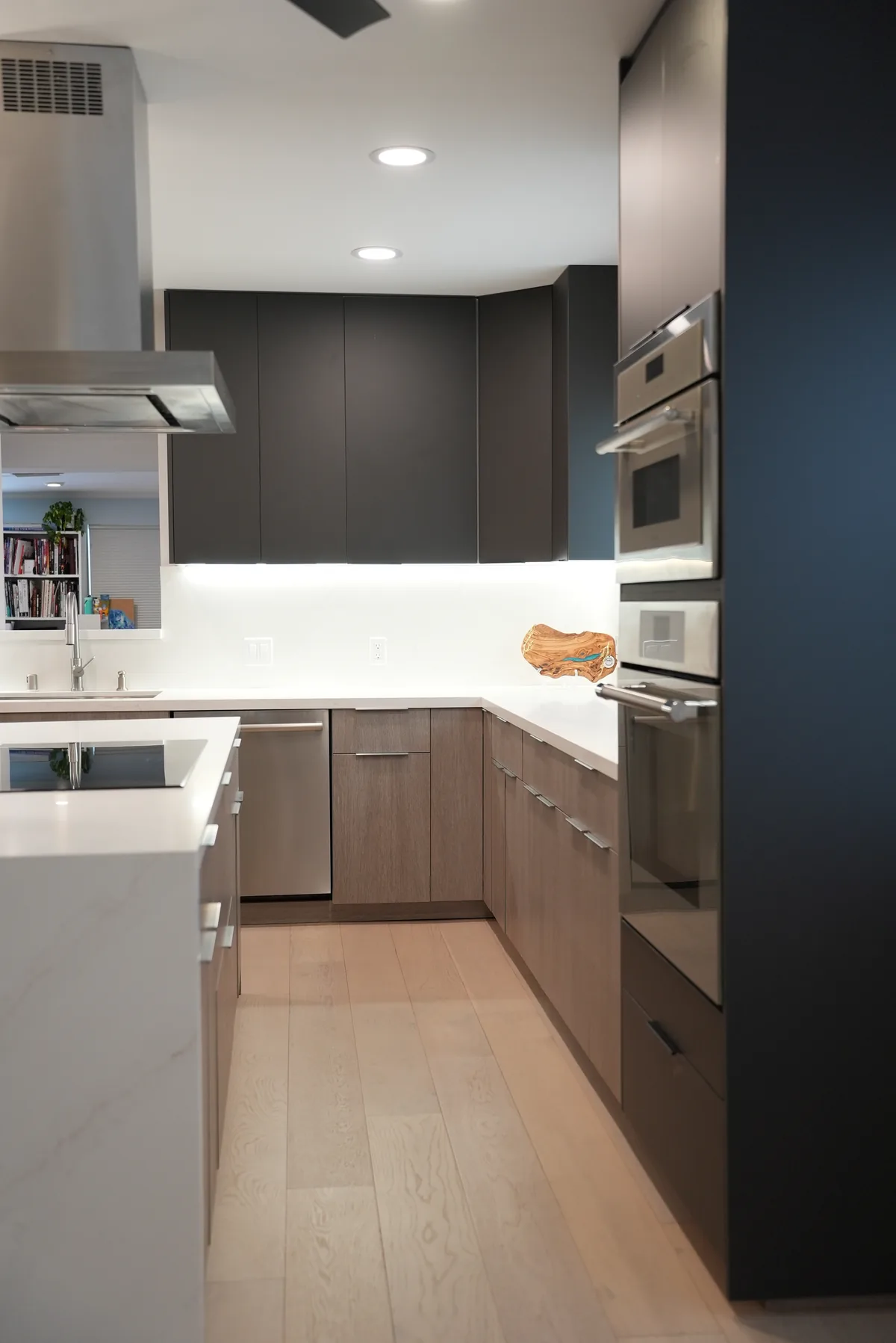European slab-front cabinets and built-in ovens beside the island
