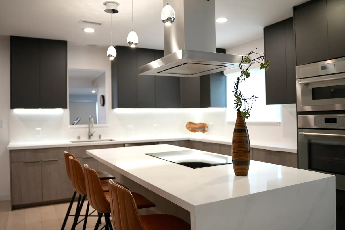 Wide view of the kitchen island, pendant lights, and anthracite upper cabinets