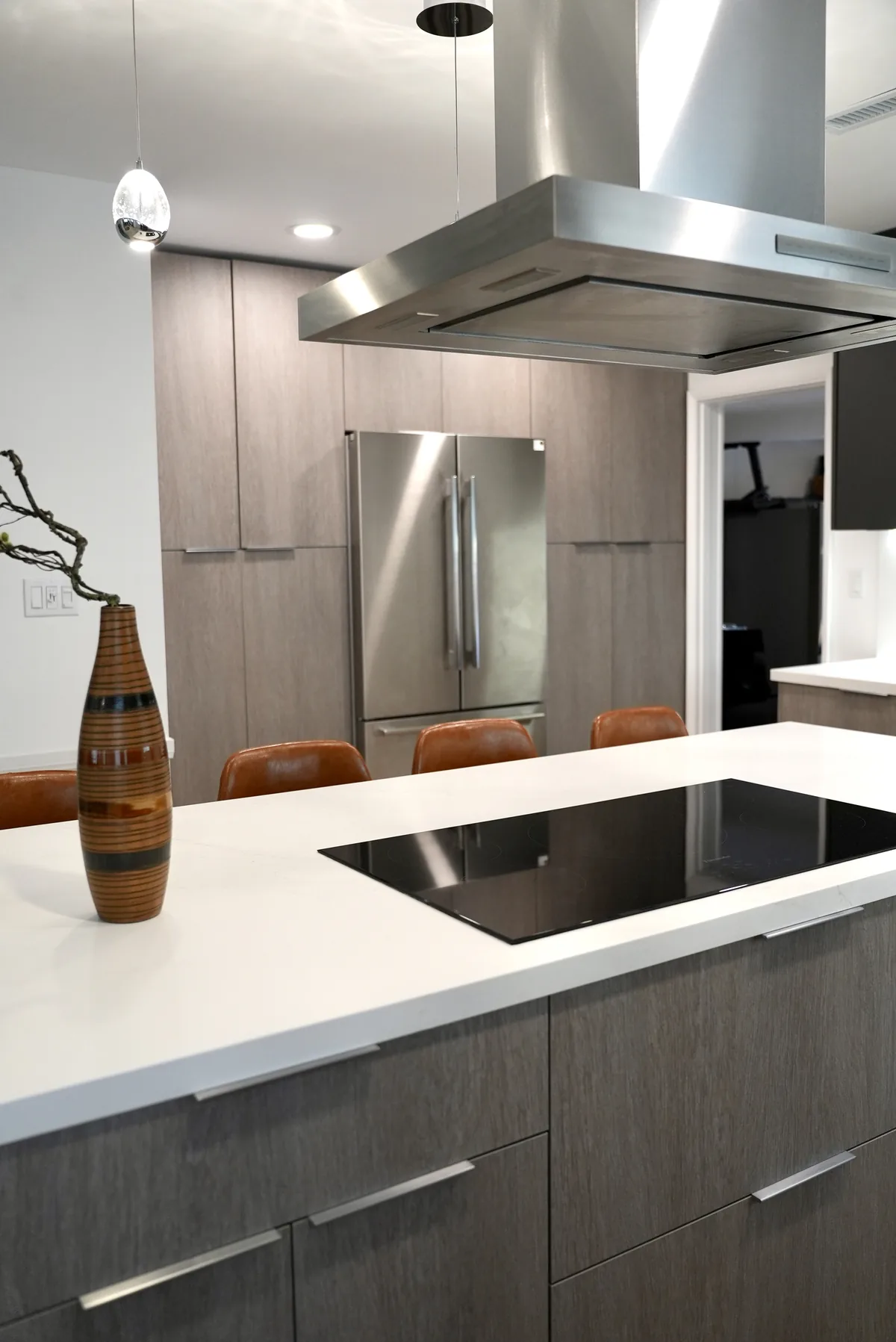 Stainless steel island hood above the black cooktop