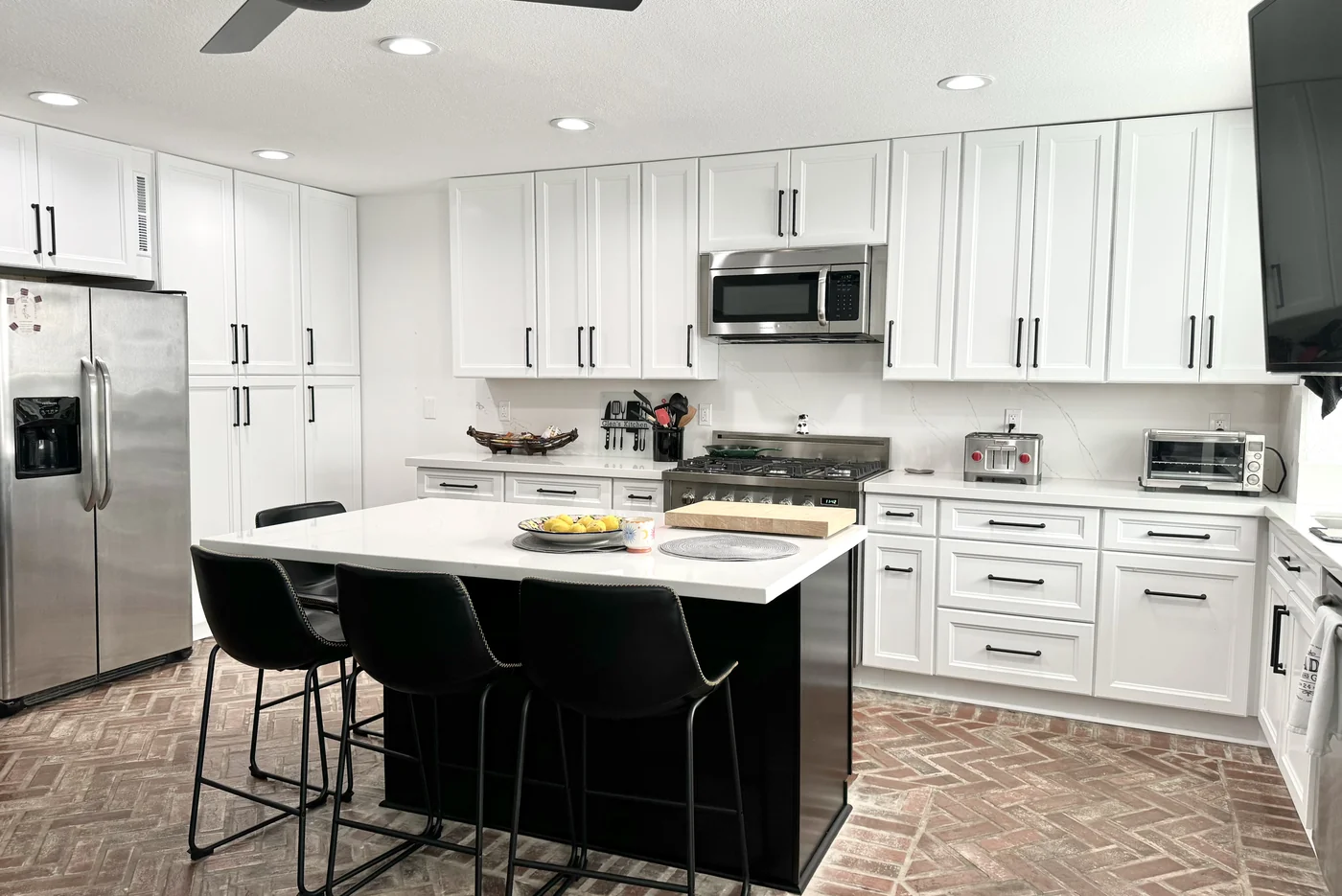 White shaker kitchen in Woodland Hills with an espresso island, white countertops, and bar seating