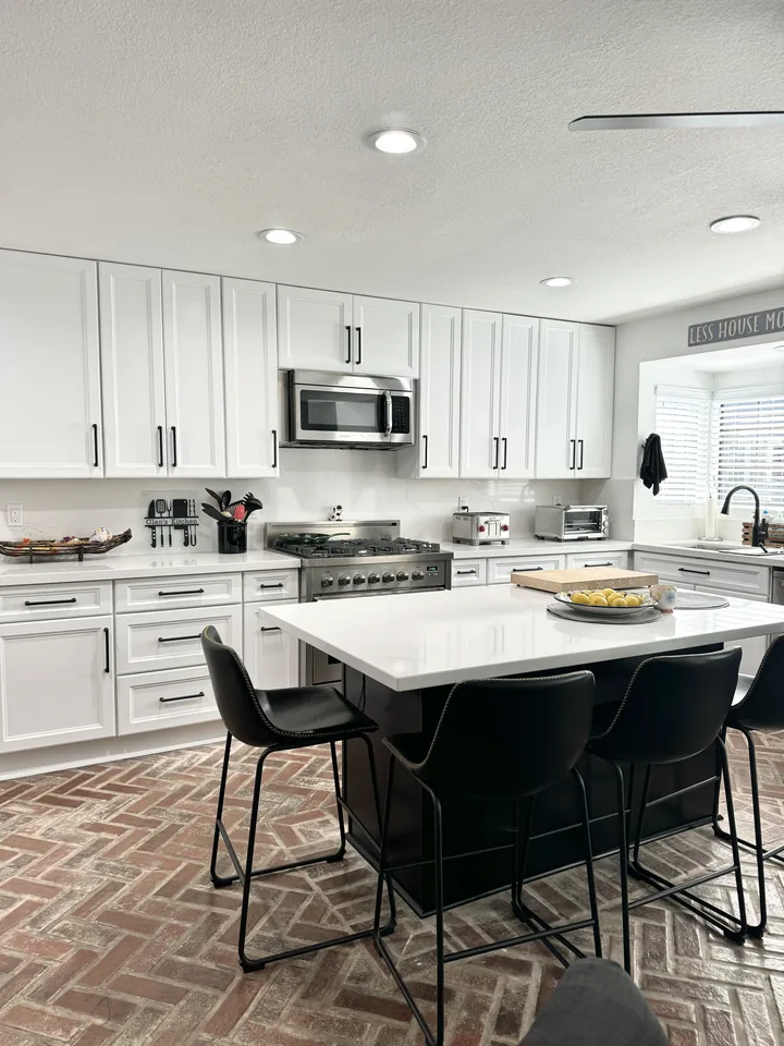 Espresso island with black bar stools and white cabinetry in Woodland Hills